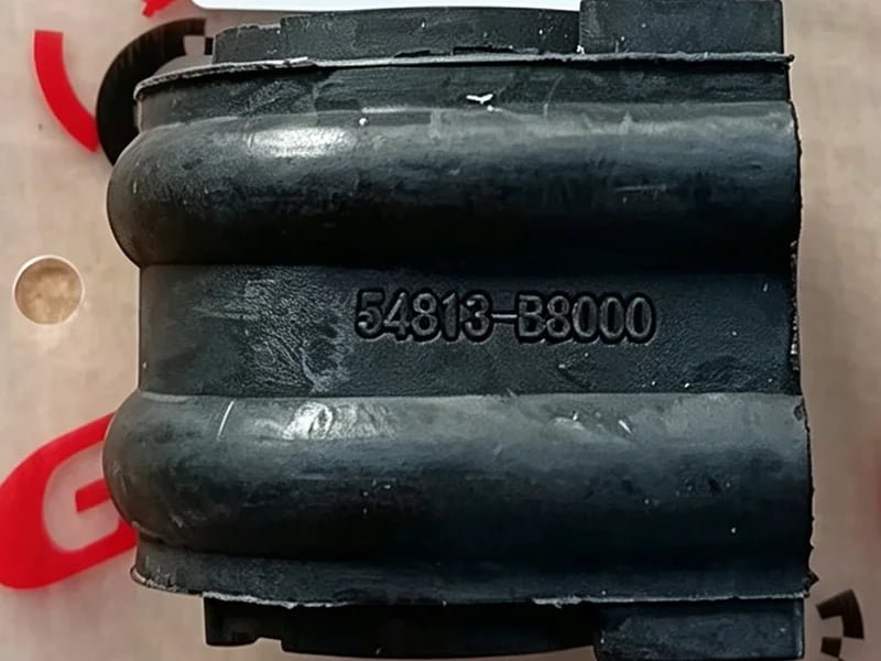 Custom brand and reference marking on an automotive bushing