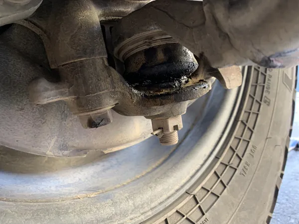 Torn ball joint dust boot causing contamination and accelerated wear