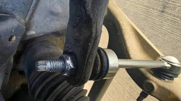Returned sway bar link nut showing cracked nylon insert from over-torque